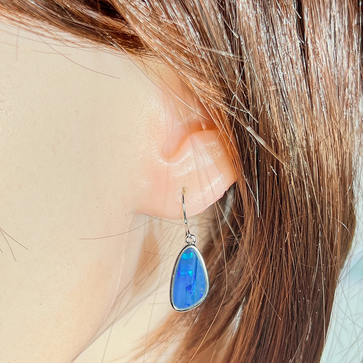freeform Australian opal doublet earrings in sterling silver, worn on the ear