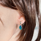Australian opal doublet earrings worn on the ear, blue, green and pink play-of-colour