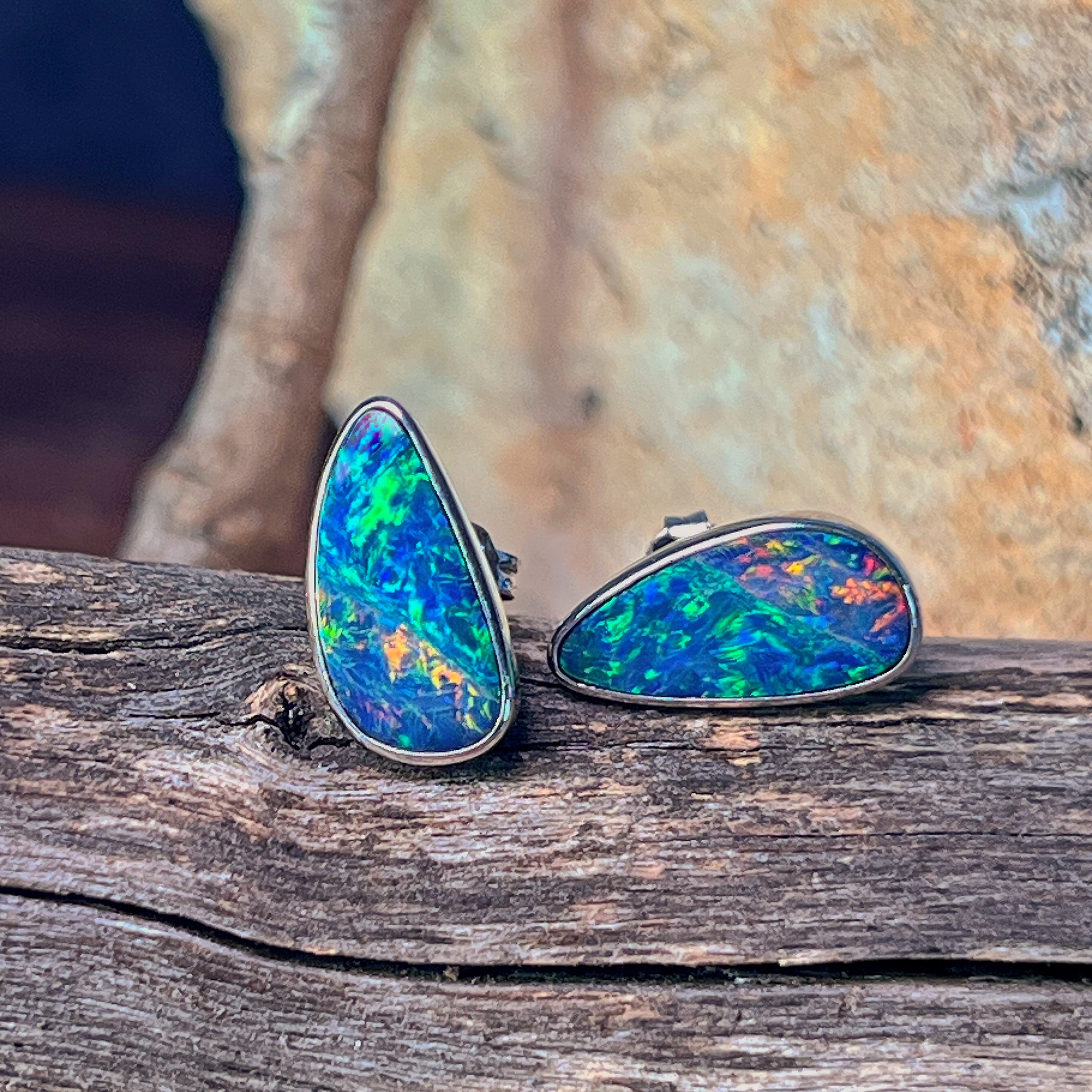 Sterling silver freeform opal doublet stud earrings standing on weathered driftwood