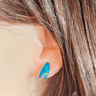 Freeform opal doublet stud earring worn on the ear, showing its scale on the earlobe