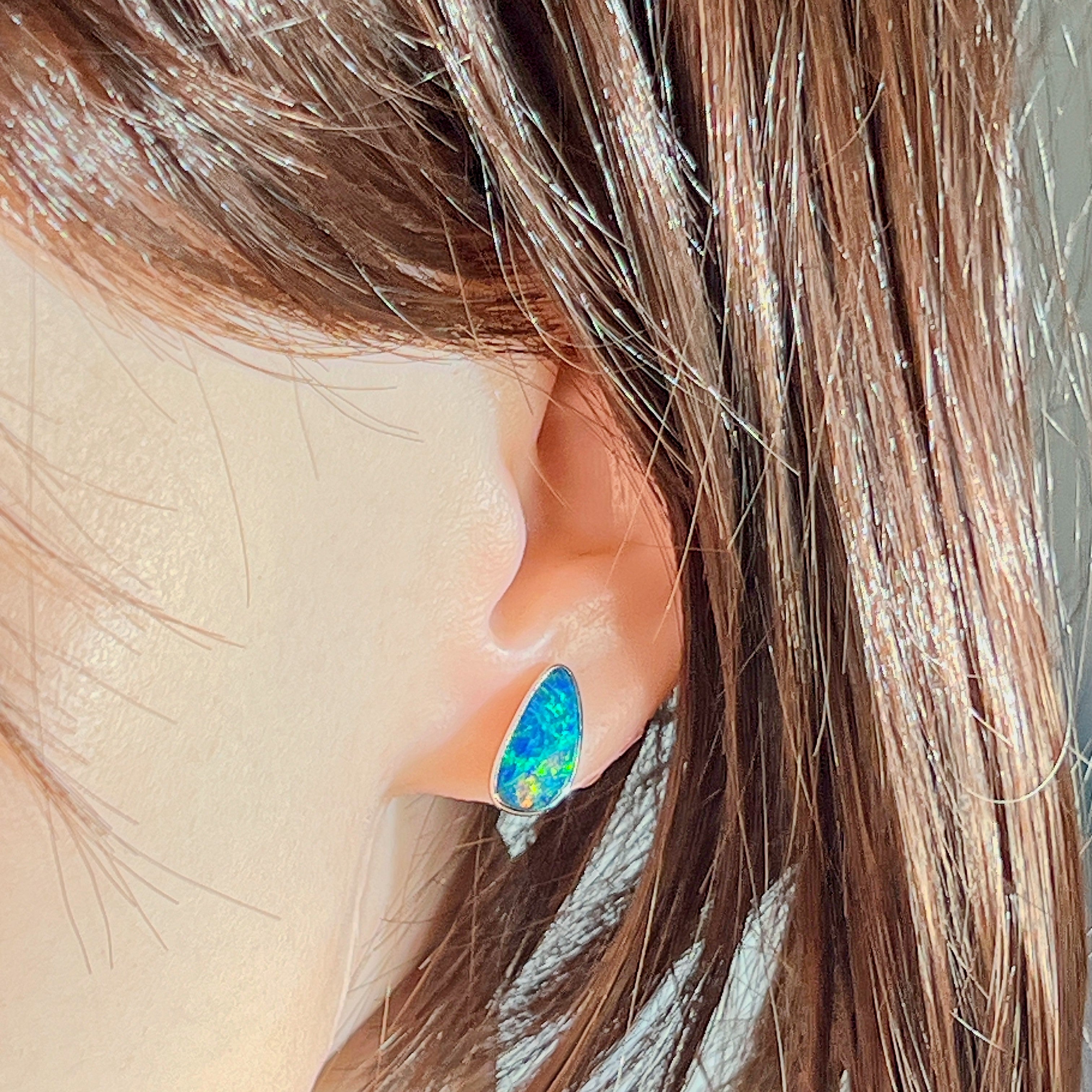 Sterling silver opal doublet stud earring worn on the ear, side profile view