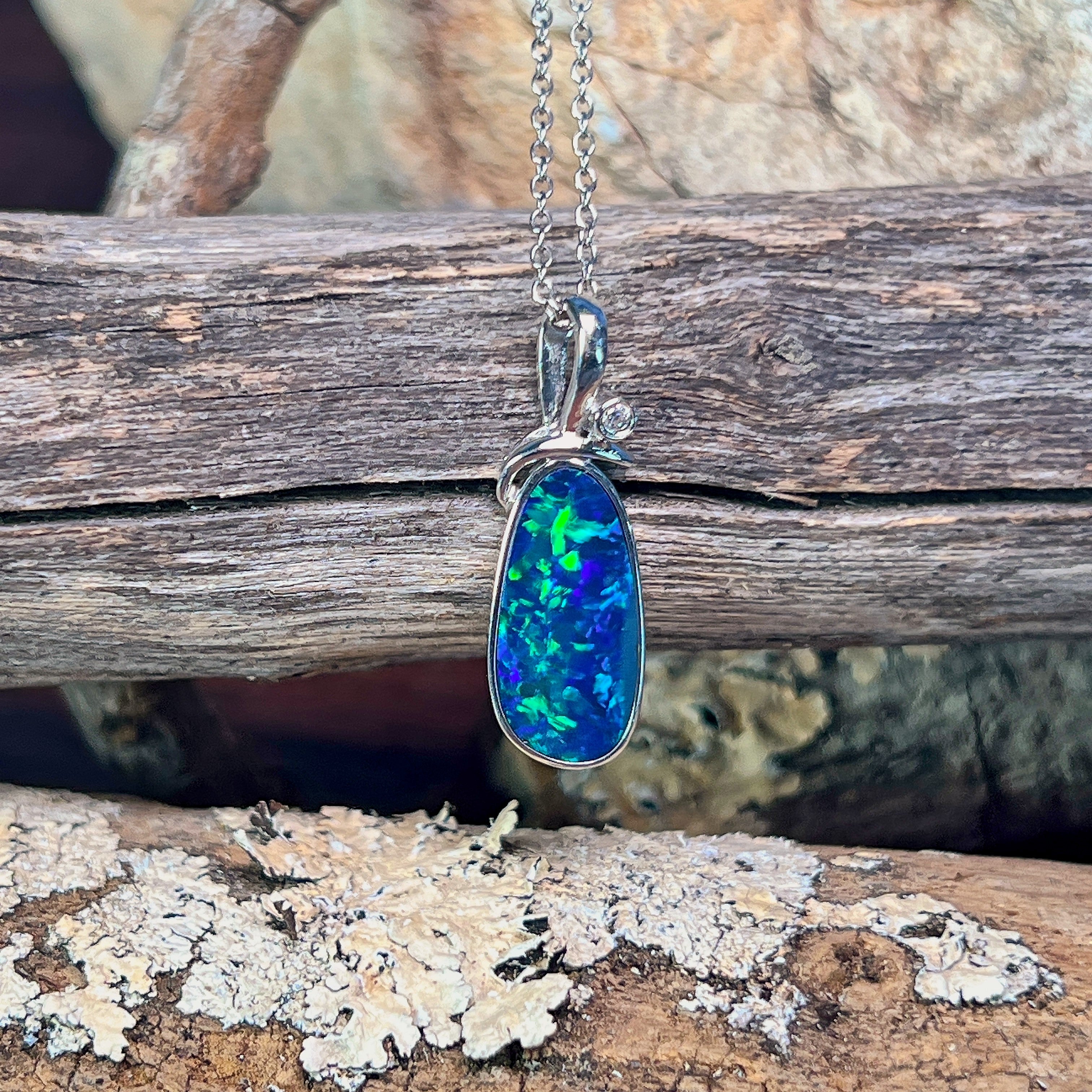 Sterling silver freeform opal doublet pendant angled to show its decorative bail