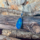 Elongated opal doublet pendant in silver showing deep blue play-of-colour