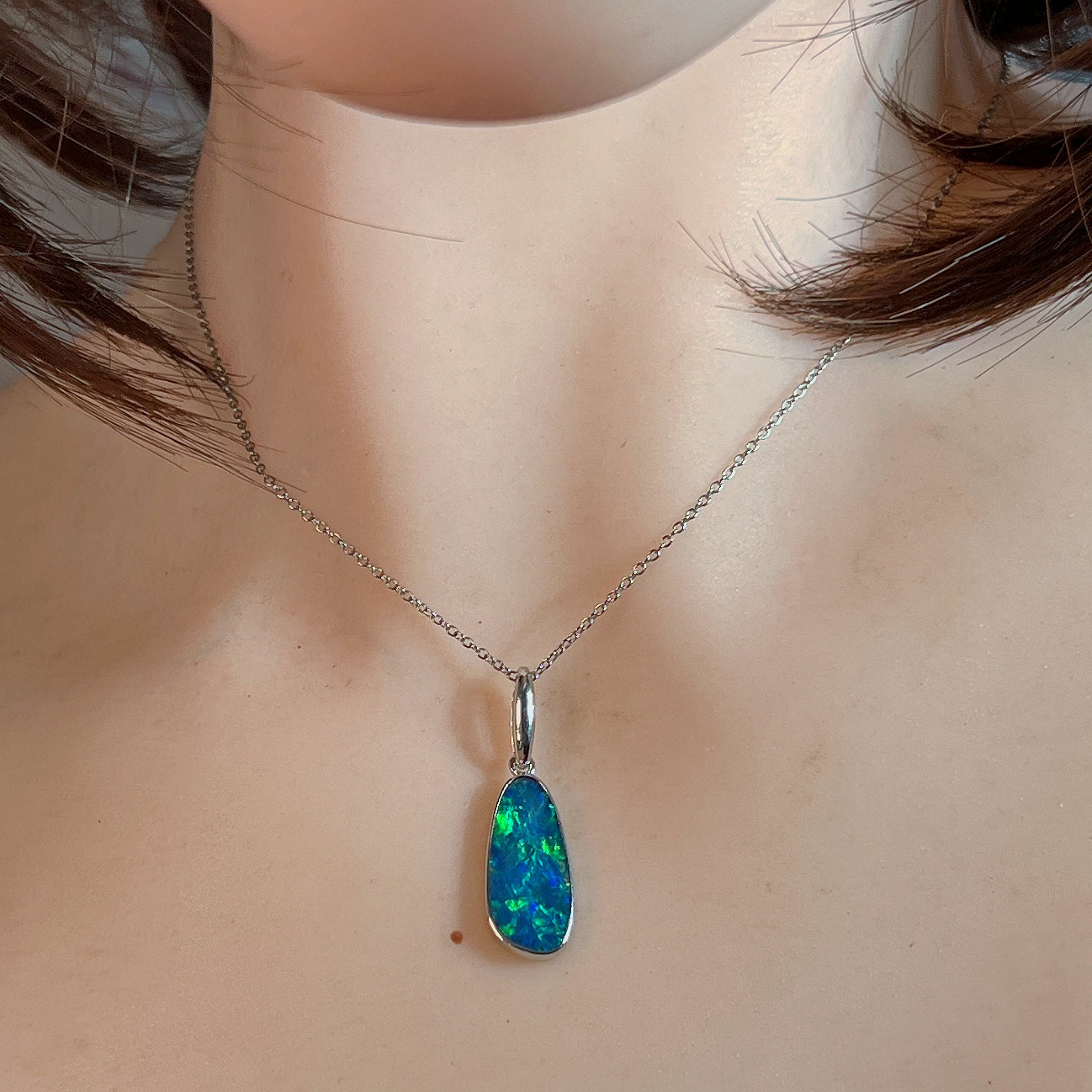 Freeform opal doublet pendant worn at the neck, showing its scale on the collarbone