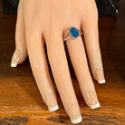 Freeform opal doublet ring in silver worn on the hand, full view across the fingers