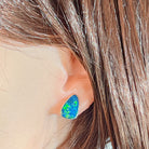 Freeform opal doublet stud earring worn on the ear, showing its scale on the earlobe