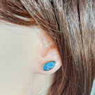 Australian opal doublet earrings worn on the ear, red, blue, yellow and green play-of-colour