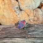 Marquise opal doublet ring in silver resting on weathered driftwood