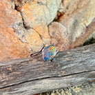 Marquise opal doublet ring in silver on driftwood against Australian sandstone