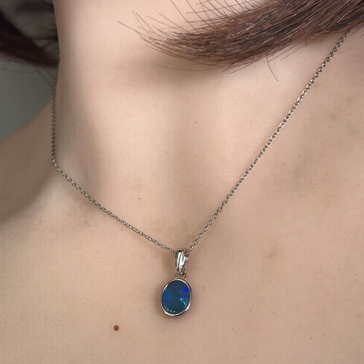 Worn Australian opal doublet pendant in sterling silver, blue, green and red, 9.5 x 7mm