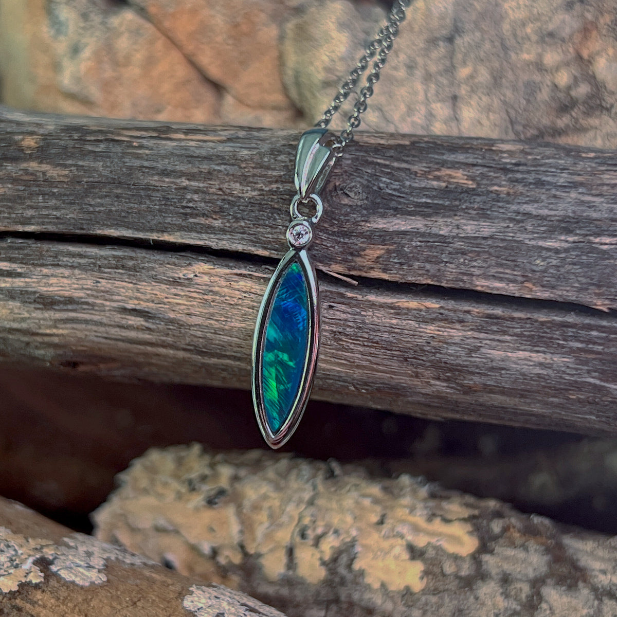 blue and green play-of-colour in a 16 x 5mm oval Australian opal doublet pendant