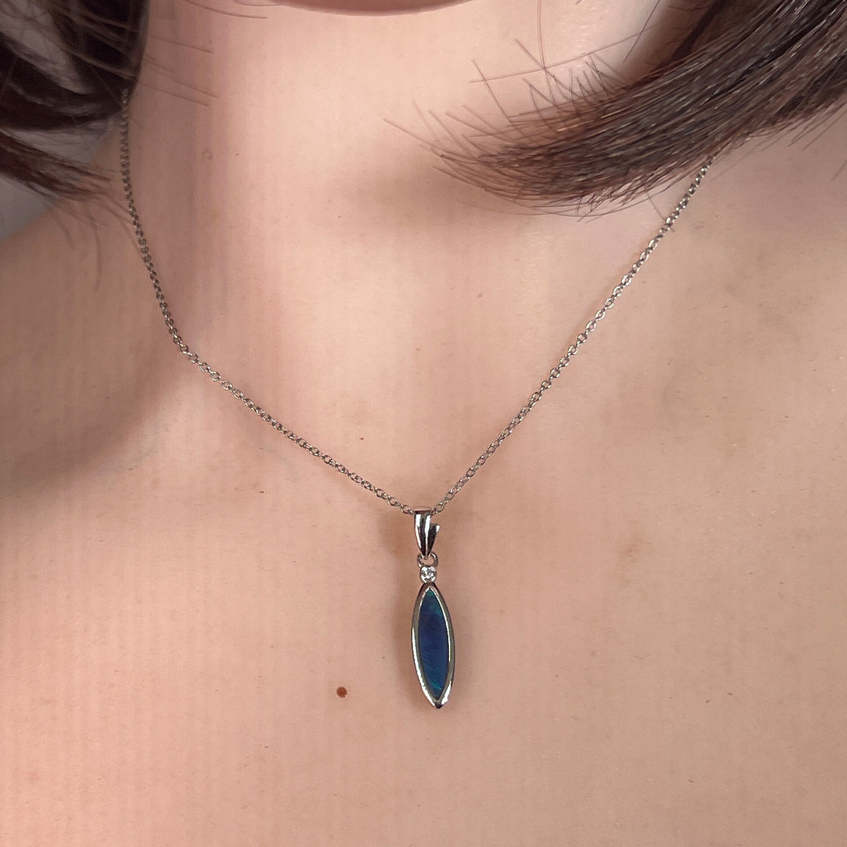 16 x 5mm oval Australian opal doublet pendant worn at the neck, sterling silver