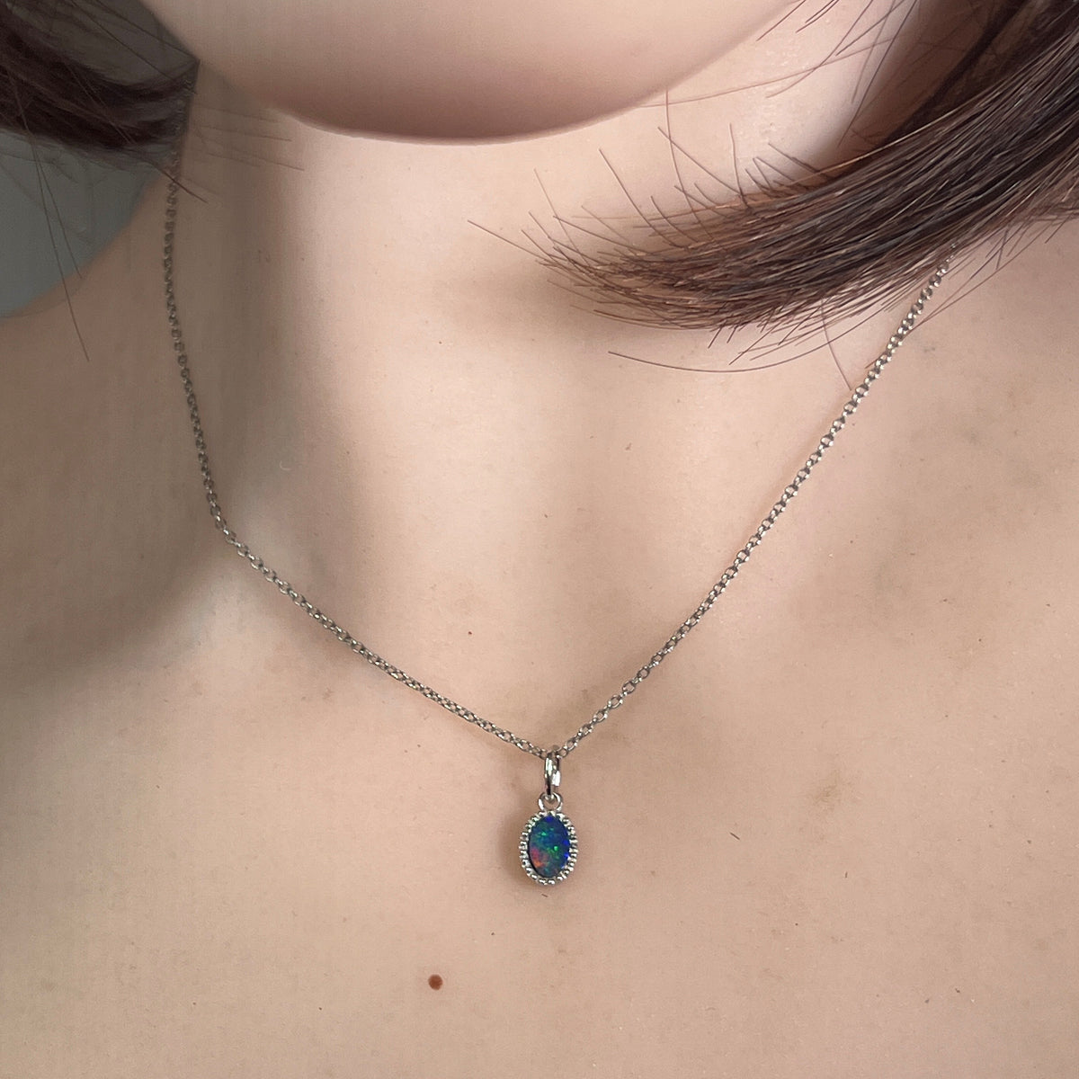 oval Australian opal doublet pendant in sterling silver, worn at the neck