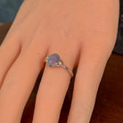 Oval opal doublet ring in silver worn on the hand, showing its scale on the finger
