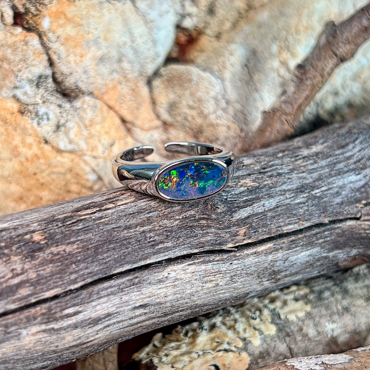 Close view of the yellow, red and green play of colour in the oval opal doublet