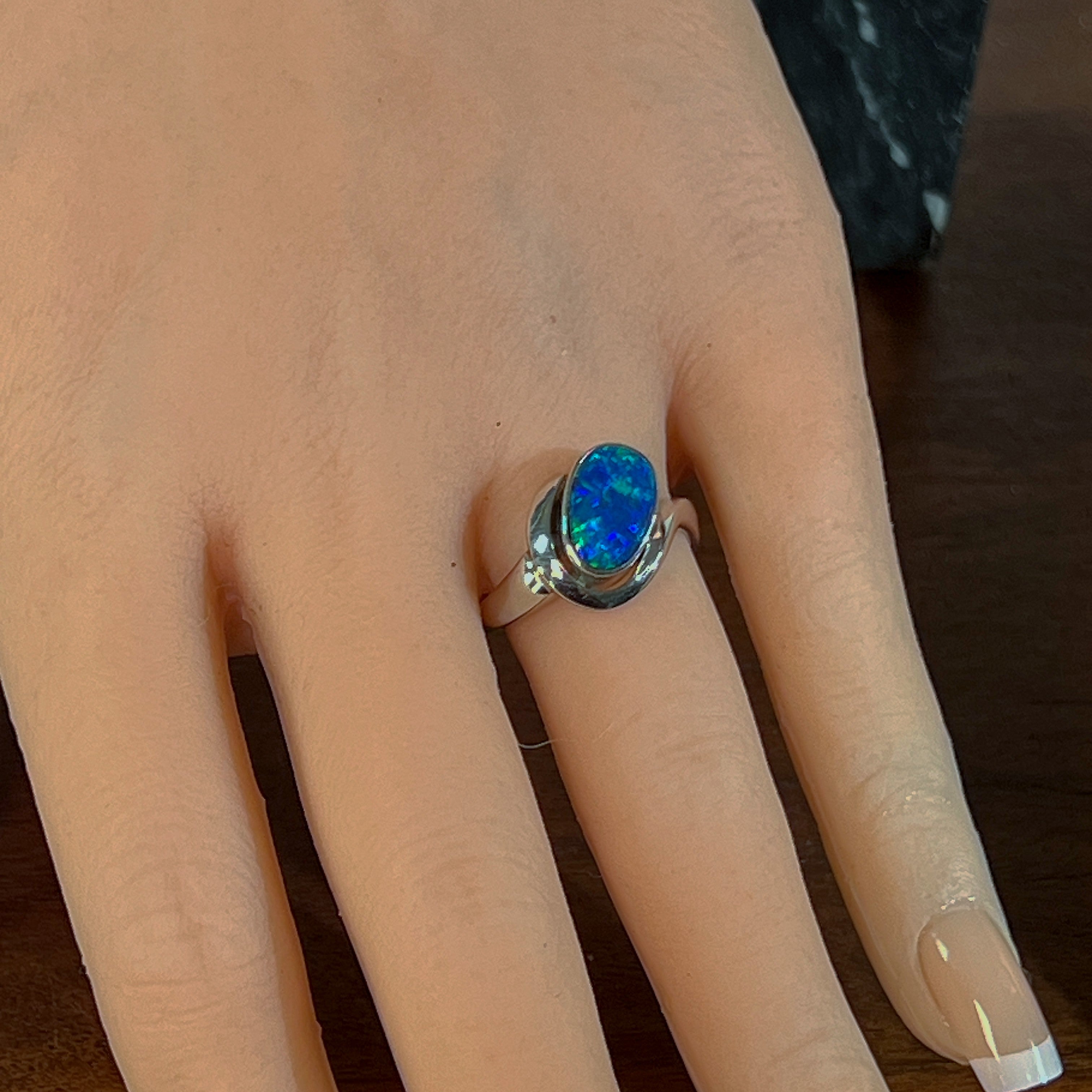 Sterling silver opal doublet ring worn on the hand, side view of the setting
