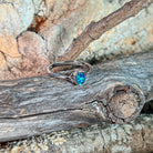 Deep green opal doublet ring in silver on driftwood against Australian sandstone