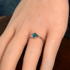 Deep green opal doublet ring in silver worn on the hand, full view across the fingers