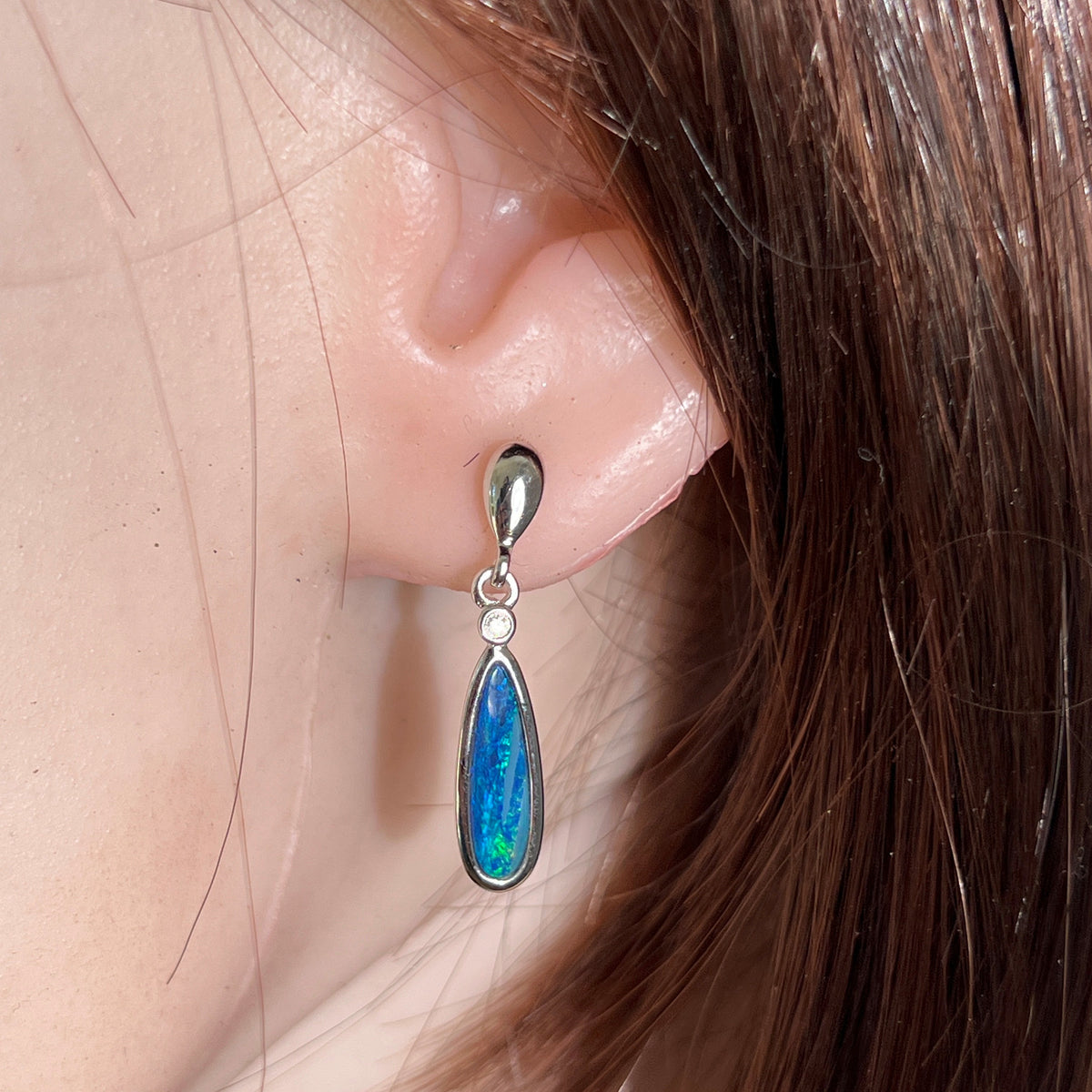 15 x 5mm pear-shaped Australian opal doublet earrings worn on the ear, sterling silver