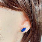 pear-shaped Australian opal doublet earrings in sterling silver, worn on the ear