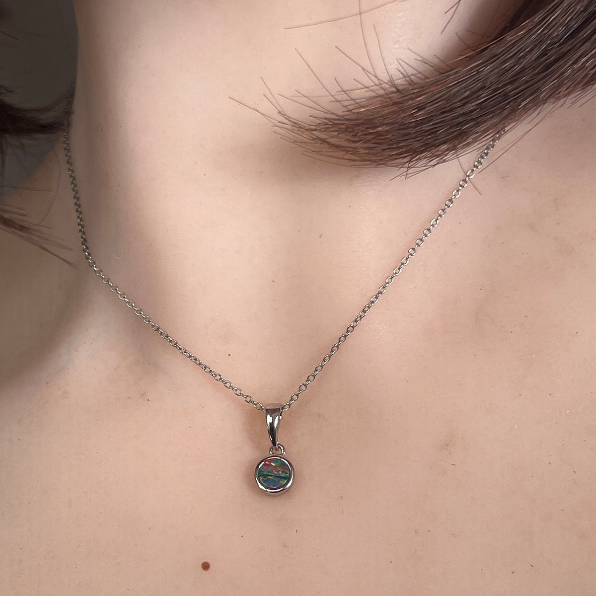 5mm round Australian opal doublet pendant worn at the neck, sterling silver