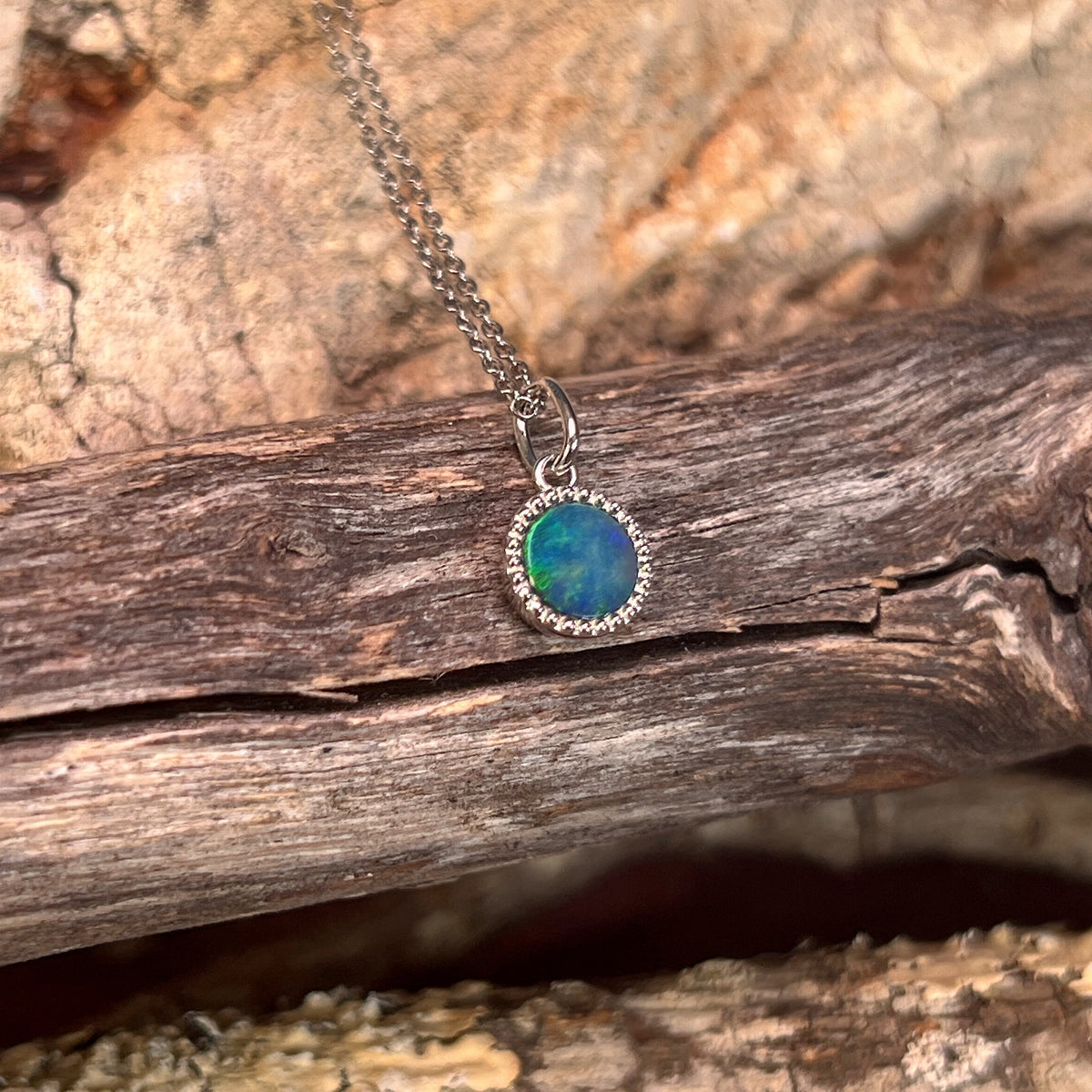 blue and green play-of-colour in a 7mm round Australian opal doublet pendant