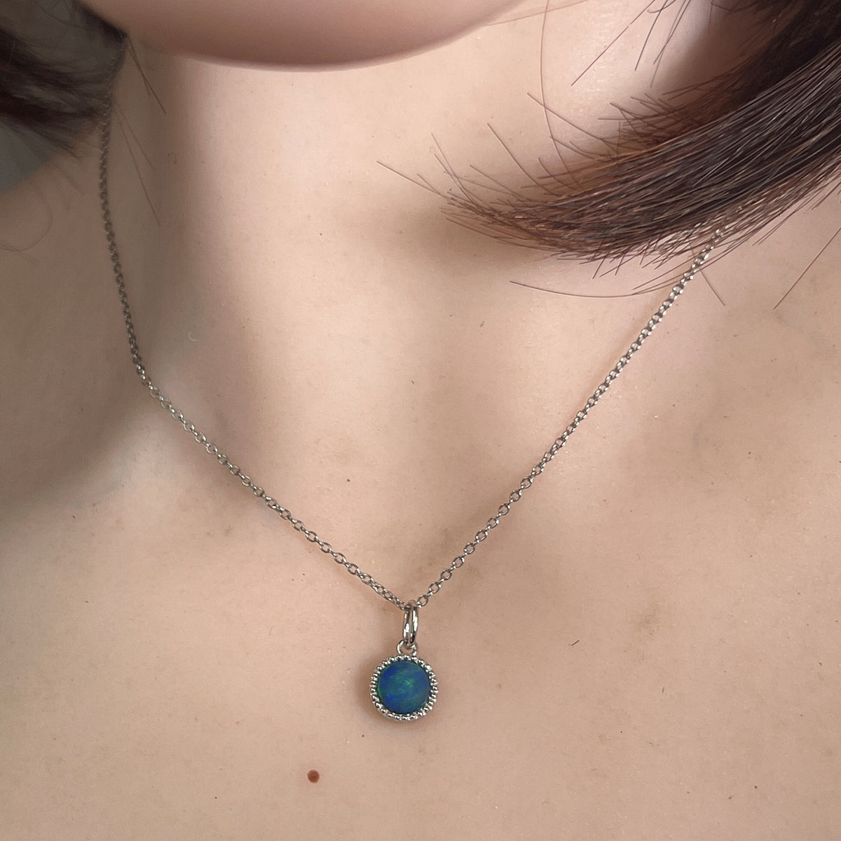 round Australian opal doublet pendant in sterling silver, worn at the neck