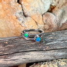 Silver ring with two round opal doublets resting on weathered driftwood