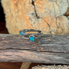 Silver ring with two round opal doublets on driftwood against Australian sandstone
