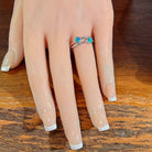 Silver ring with two round opal doublets worn on the hand, full view across the fingers