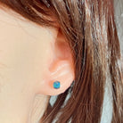 5mm round Australian opal doublet earrings worn on the ear, sterling silver