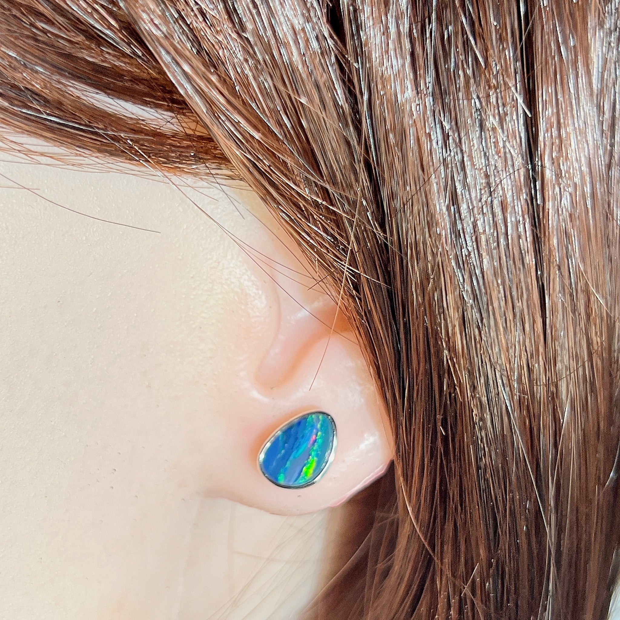 Worn Australian opal doublet earrings in sterling silver, red, blue and green, 10 x 7mm