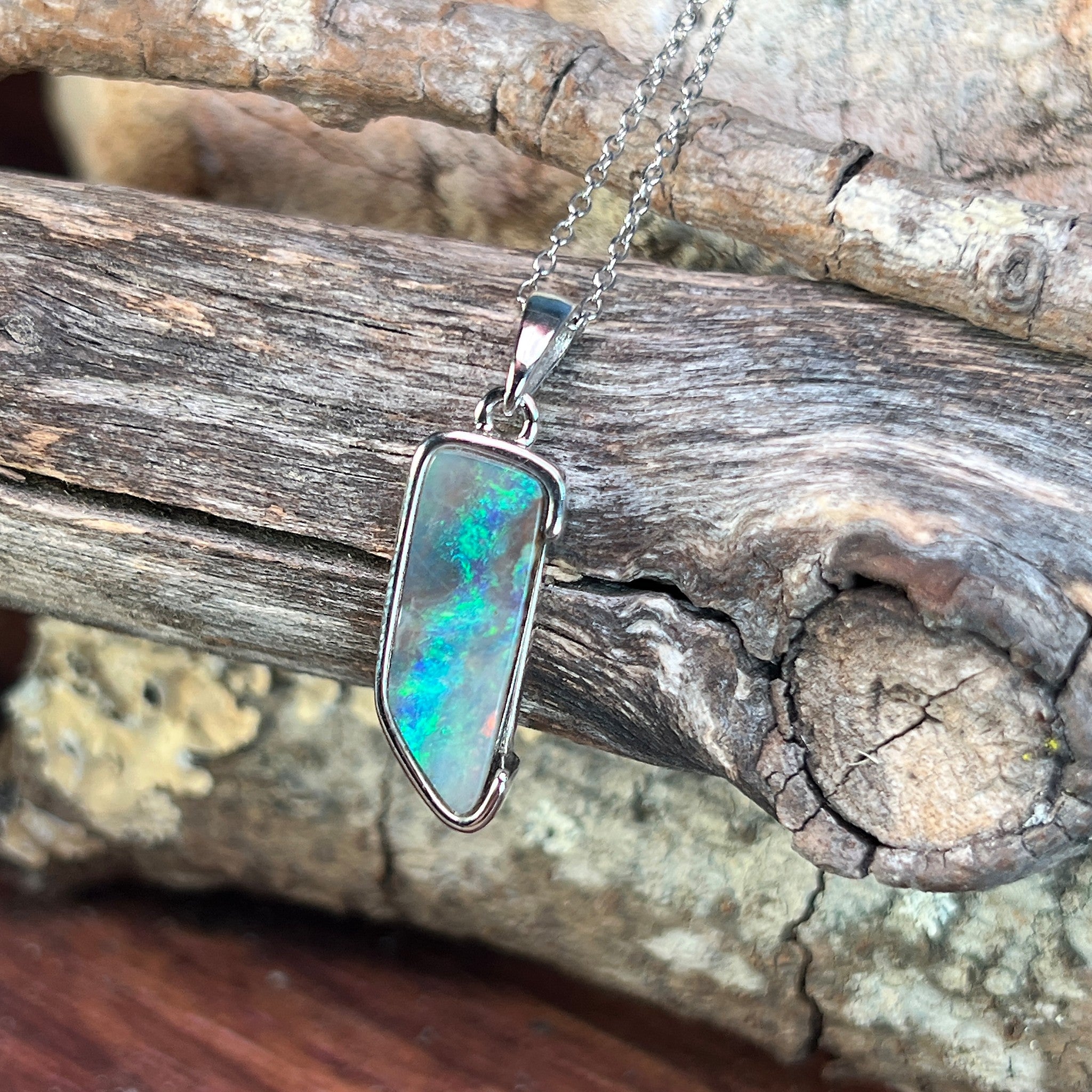 brown, green and blue play-of-colour in an 18 x 7mm freeform Australian boulder opal pendant