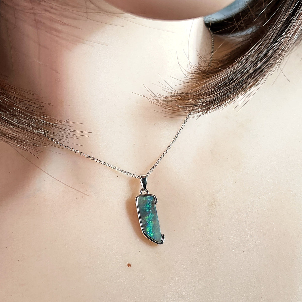 Australian boulder opal pendant worn at the neck, brown, green and blue play-of-colour