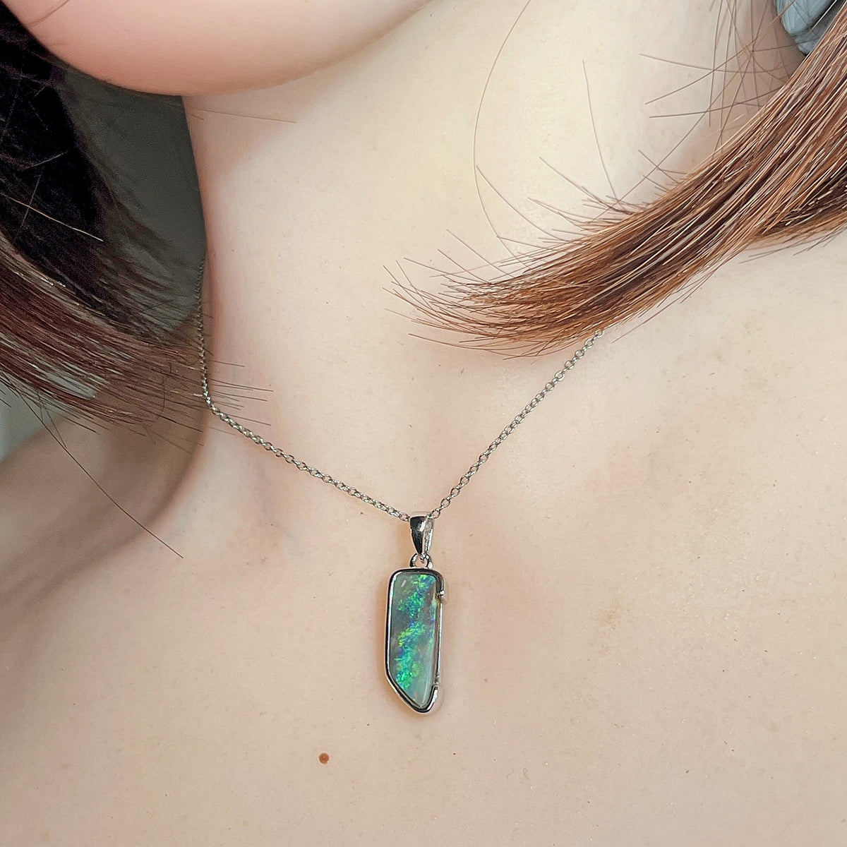 18 x 7mm freeform Australian boulder opal pendant worn at the neck, sterling silver