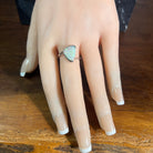Sterling silver triangular crystal opal ring, solid Australian opal 13x10mm, green and blue, shown on a display hand