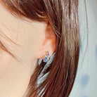 Opal triplet earring in sterling silver worn on the ear, side profile view