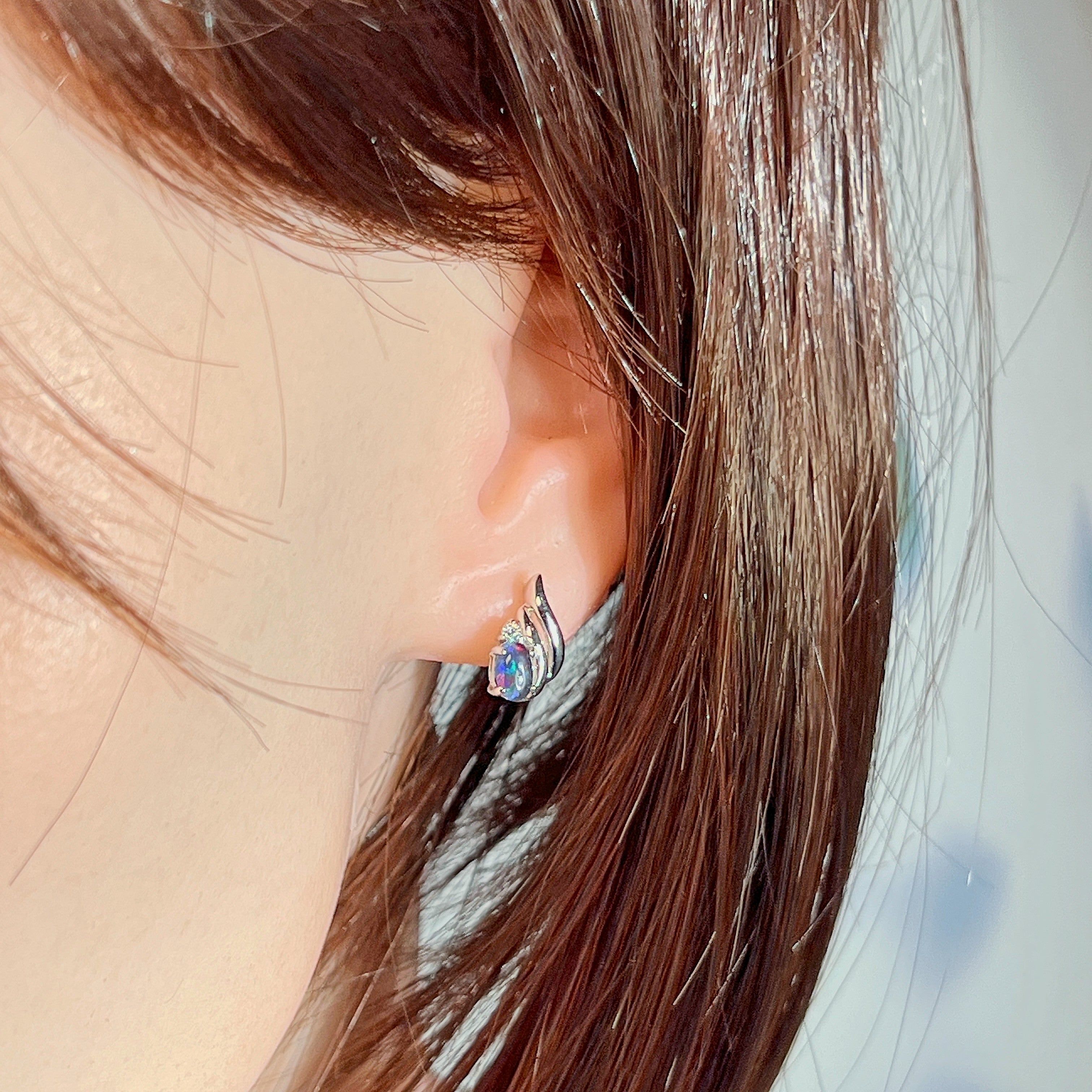 Opal triplet earring in sterling silver worn on the ear, side profile view