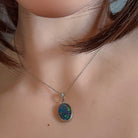 Oval opal triplet pendant worn at the neck, showing its scale on the collarbone