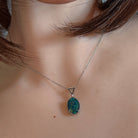 Opal triplet pendant worn at the neck, close view of the claw setting