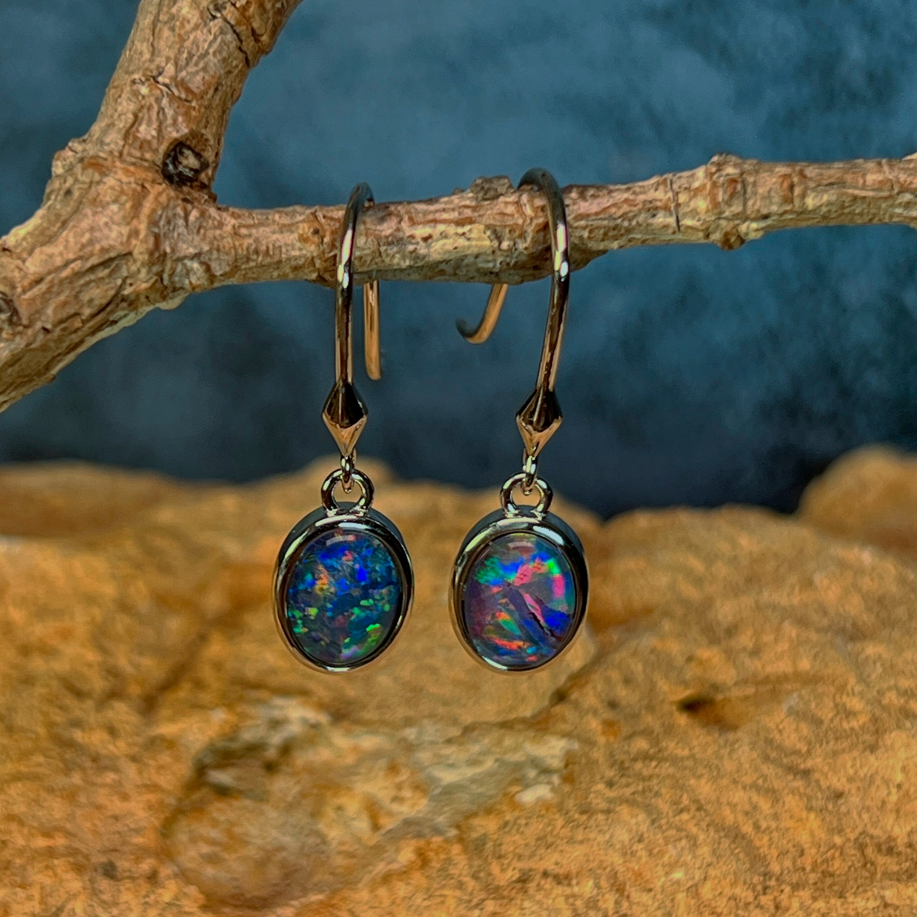 Front view of sterling silver hook earrings with blue green opal triplets above sandstone
