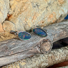 Pair of opal triplet cufflinks in silver on driftwood against Australian sandstone