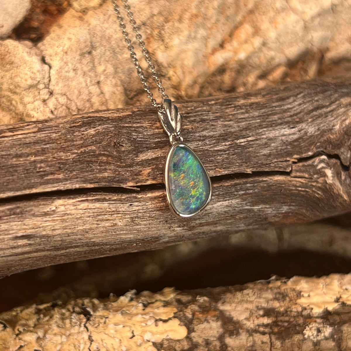 blue, green and yellow play-of-colour in a 12 x 8mm freeform Australian opal triplet pendant