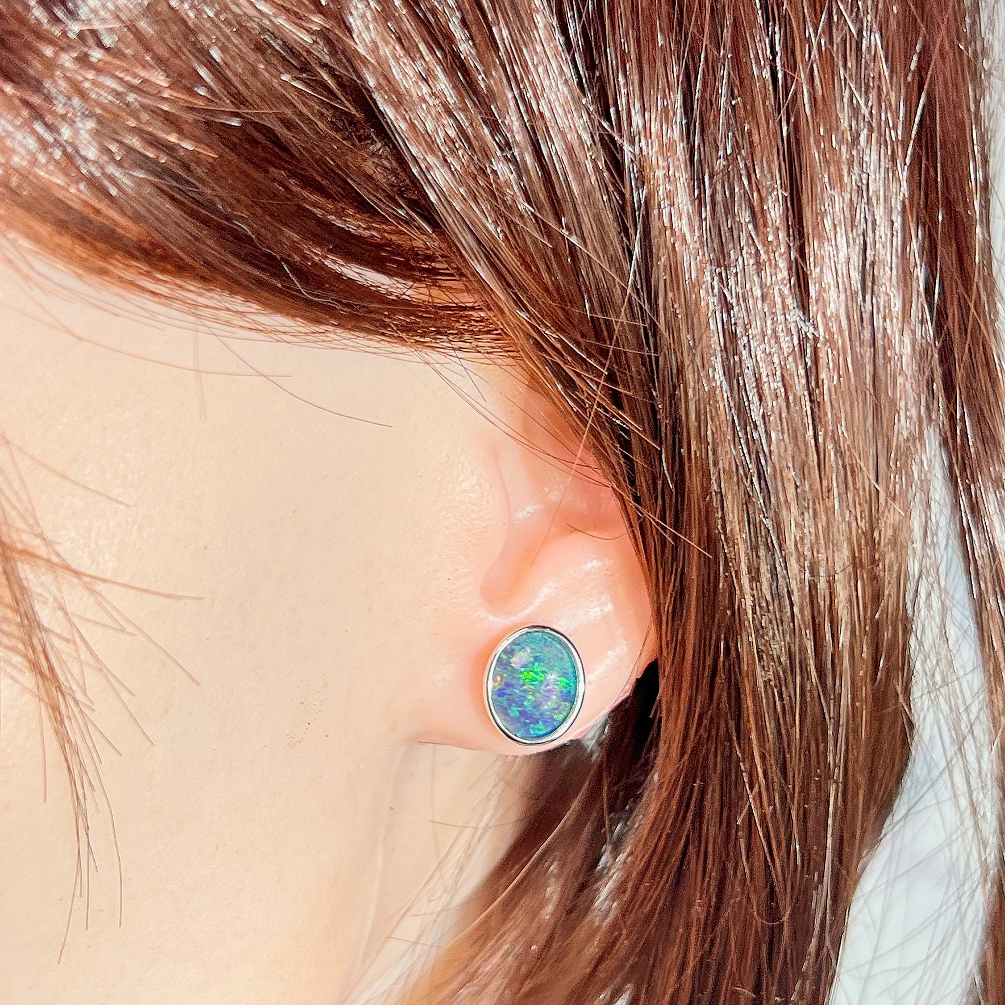 11 x 9mm oval Australian opal triplet earrings worn on the ear, sterling silver