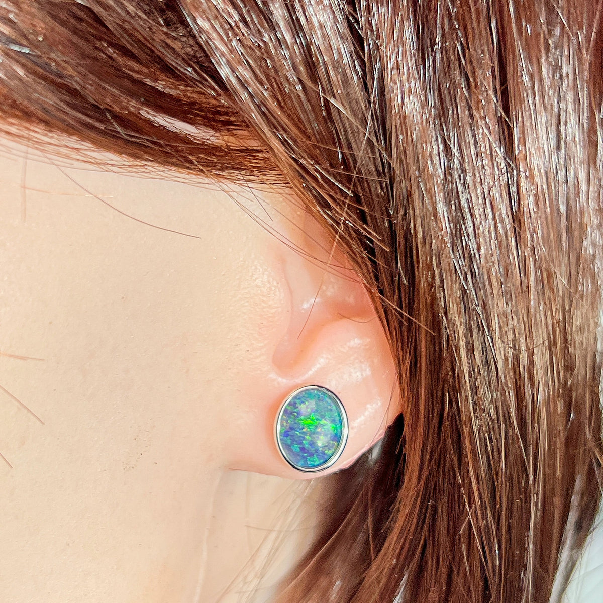 Australian opal triplet earrings worn on the ear, sterling silver, 11 x 9mm oval stones