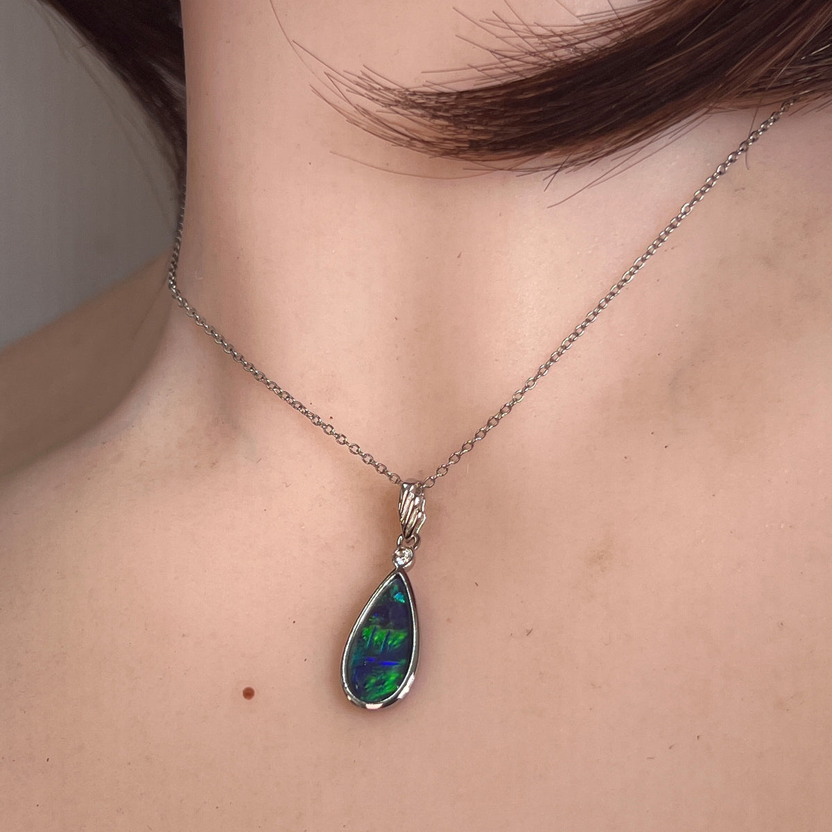 16 x 8mm pear-shaped Australian opal triplet pendant worn at the neck, sterling silver