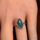 Australian opal triplet ring worn on the hand, yellow, blue and green play-of-colour