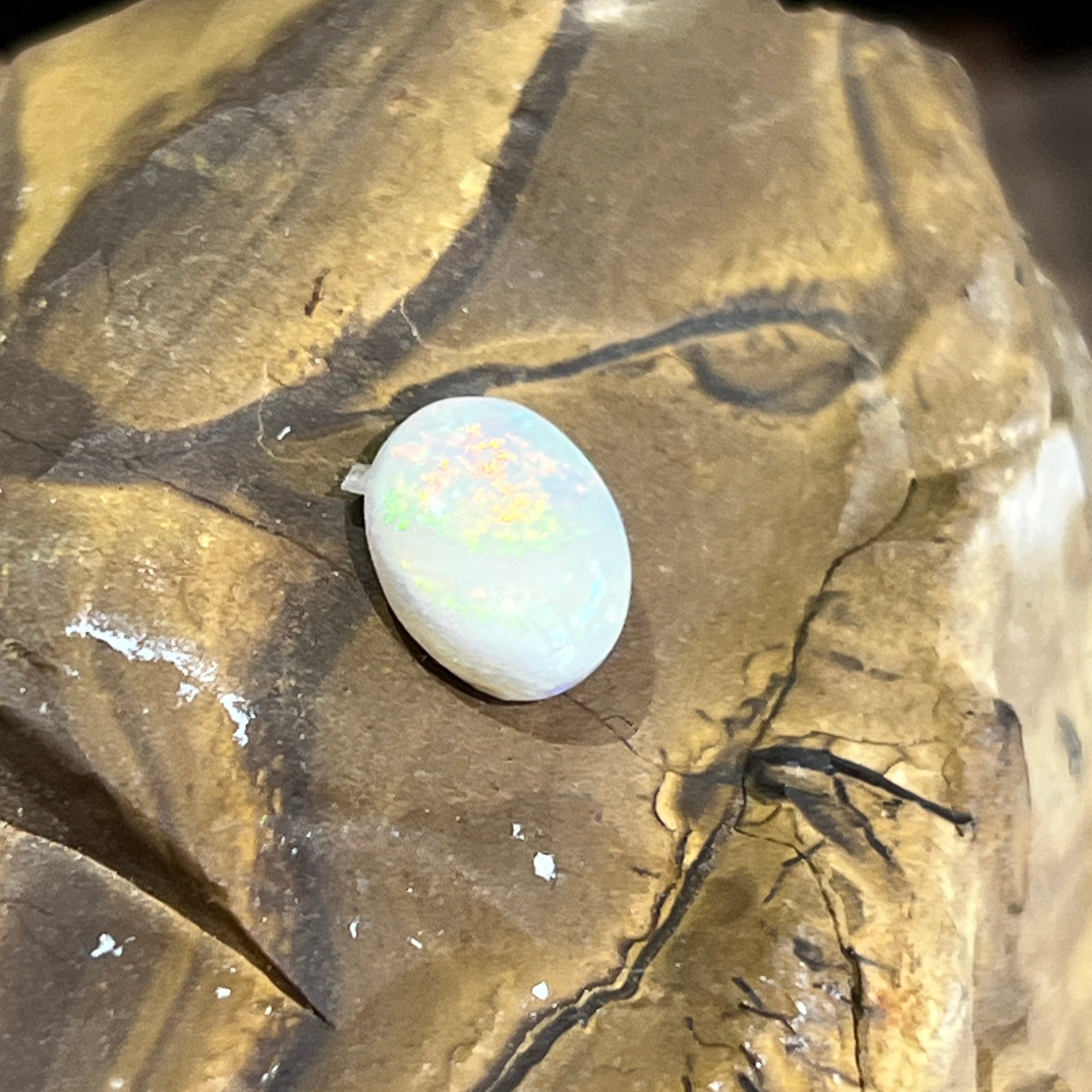 1.1ct Australian white opal angled on ironstone, soft green and gold play of colour
