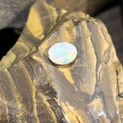 Australian white opal oval resting on ironstone, soft pastel play of colour