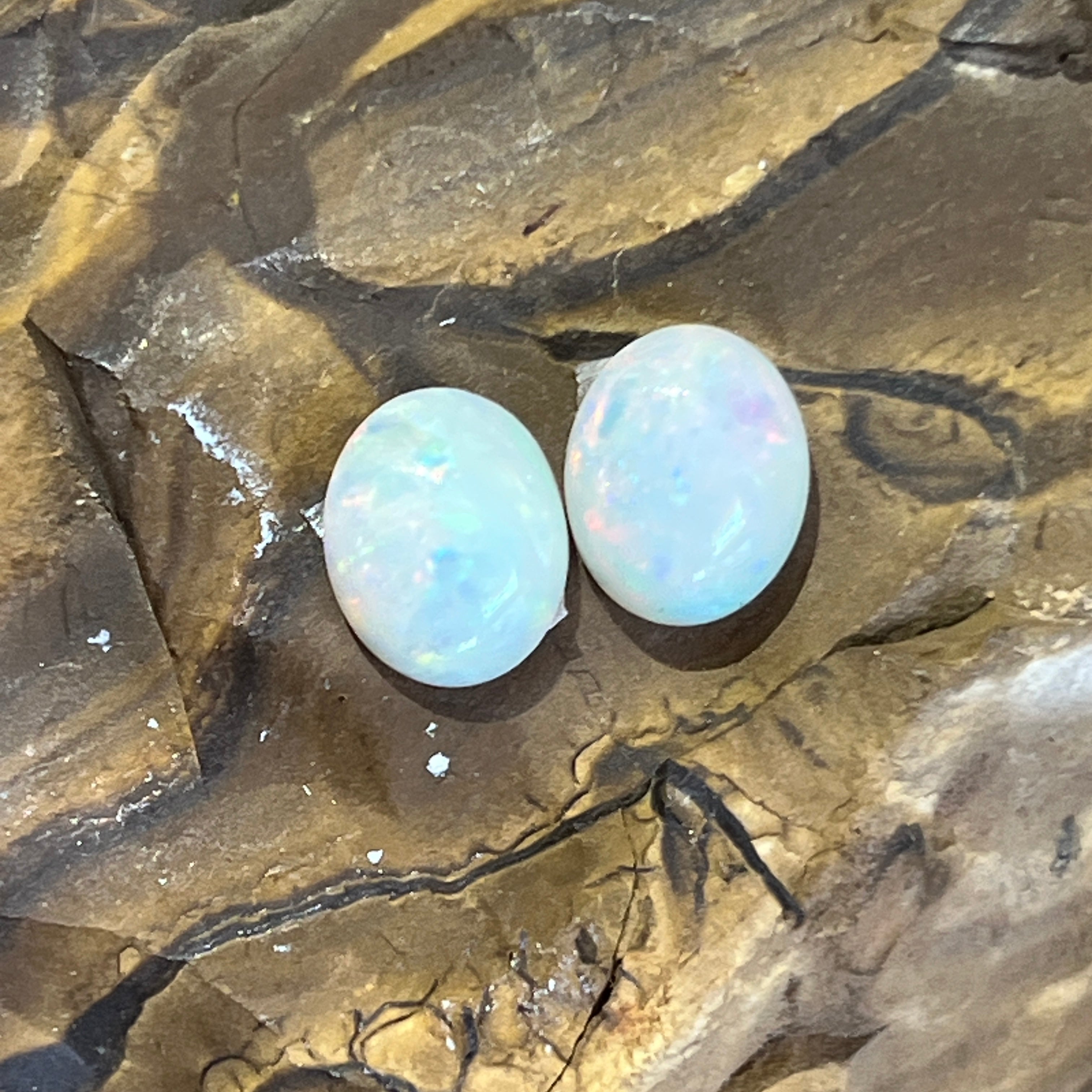 Pair of Australian white opals, 3.23ct for the two stones, side by side on ironstone